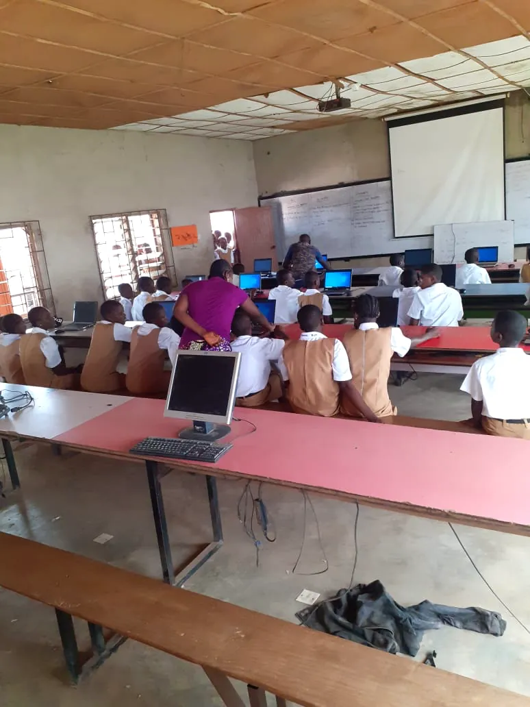 A teacher guiding students during a computer lesson